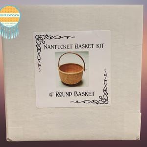 Puede incluir: Una caja cuadrada con una etiqueta que dice "Nantucket Basket Kit". La etiqueta presenta una cesta redonda de 10 cm con un asa. La caja también tiene un logotipo que dice "HH Perkins Co."