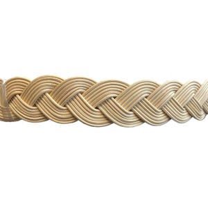 May include: Close-up of a woven, light brown wicker basket rim. The basket rim is made of thin, parallel strips of wicker, intricately woven in a braided pattern. The natural color of the wicker is a light tan, with subtle variations in tone.