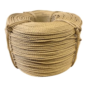 May include: A large, cylindrical coil of tan-colored twisted rope. The rope is wound in a tight, uniform circular pattern and secured with several strands of the same material wrapped around the exterior to maintain its compact, bundled shape.