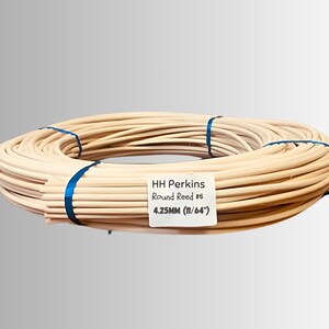 May include: A bundle of HH Perkins Round Reed, tied with blue ribbon. The reed is a light tan color and is labeled as 4.25mm (11/64"). This product is likely used for weaving or crafting.
