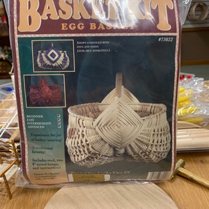 May include: A basket weaving kit for an egg basket. The kit includes reed, two 8-inch round hoops, and instructions. The finished basket is 6 inches tall, 9 inches wide, and 8 inches deep. The kit is shown with the basket enhanced with dyes and stains, which are available separately.
