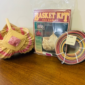 May include: A basket weaving kit with a finished egg basket, a roll of 1/4 inch pastel paper reed, and instructions. The kit is labeled "Basket Kit Egg Basket #73022".