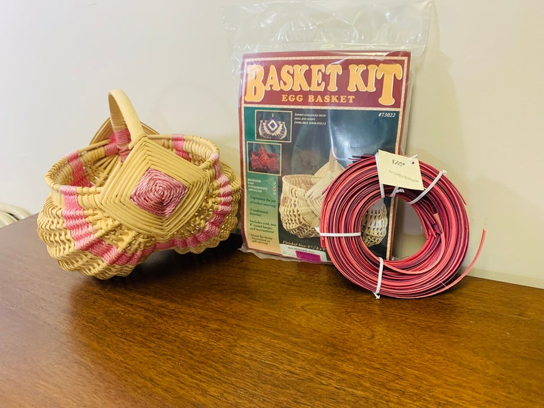 May include: A wicker egg basket kit with pink and natural colored reeds. The kit includes a booklet with instructions and a roll of red reed.
