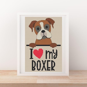 May include: Cross stitch pattern featuring a cartoon boxer dog peeking over a sign that says "I love my boxer" with a red heart.