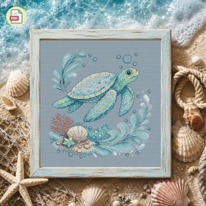 Könnte beinhalten: Ein gerahmtes Kreuzstichmuster mit einer Meeresschildkröte, die in einer aquatischen Szene schwimmt. Die Schildkröte ist hellgrün und blau, umgeben von Blasen, Korallen und Seegras. Der Rahmen ist hellblau, der Hintergrund zeigt Muscheln und Sand.
