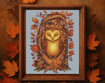May include: A framed cross-stitch artwork featuring a golden owl nestled in a tree hollow, surrounded by autumn leaves and berries. The artwork is set against a light blue background, with a wooden frame. The overall color palette is warm, with shades of brown, orange, and gold.