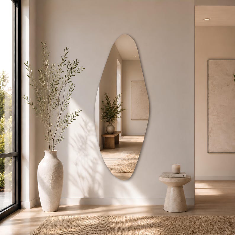 Large frameless geometric organic wall mirror featuring a tall sculptural silhouette with softly faceted contours and polished edges. Crafted from premium-quality mirror glass, it delivers a bright, natural reflection while adding artistic depth and visual interest to any space. Ideal for entryways, living rooms, bedrooms, dressing areas, and hallways. Its distinctive contemporary design complements modern, minimalist, Scandinavian, Japandi, and luxury interiors.