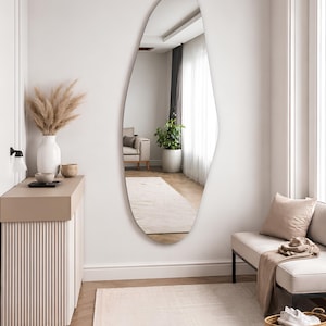 Large frameless geometric organic wall mirror featuring a tall sculptural silhouette with softly faceted contours and polished edges. Crafted from premium-quality mirror glass, it delivers a bright, natural reflection while adding artistic depth and visual interest to any space. Ideal for entryways, living rooms, bedrooms, dressing areas, and hallways. Its distinctive contemporary design complements modern, minimalist, Scandinavian, Japandi, and luxury interiors.