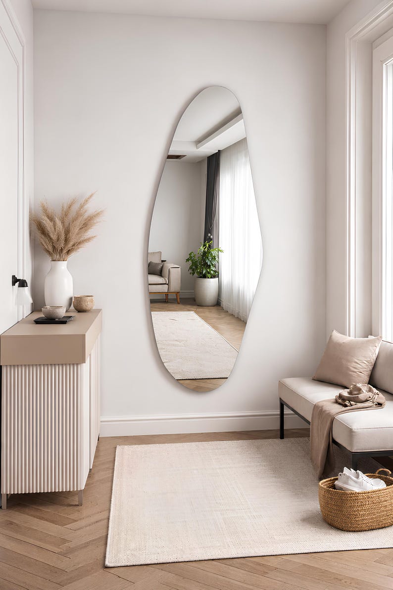 Large frameless geometric organic wall mirror featuring a tall sculptural silhouette with softly faceted contours and polished edges. Crafted from premium-quality mirror glass, it delivers a bright, natural reflection while adding artistic depth and visual interest to any space. Ideal for entryways, living rooms, bedrooms, dressing areas, and hallways. Its distinctive contemporary design complements modern, minimalist, Scandinavian, Japandi, and luxury interiors.