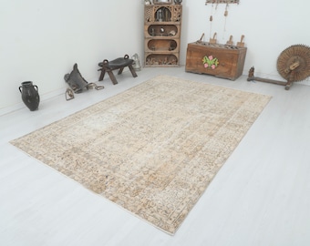 May include: A vintage, off-white rug with a faded floral pattern and a distressed look. The rug has a subtle border and a worn, antique appearance.