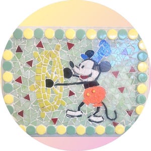 May include: A mosaic artwork featuring Mickey Mouse in his classic attire, interacting with a yellow object. The mosaic is set against a light green background with red triangle accents and bordered by yellow and green circles.
