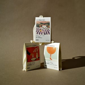 May include: Three small white fabric pouches with colourful illustrations and the text "nose" printed on the bottom. The pouches are labelled "En Provence", "Breakfast at Jasmine's", and "Choose Summer II".