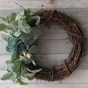 Grapevine wreath with greenery and flower