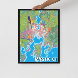 May include: A framed art print of a colorful map of Mystic, CT. The map features a vibrant mix of colors, including blue for the water, green for the land, and various hues for buildings and roads. The text "MYSTIC CT" is displayed in white at the bottom.