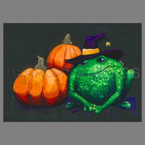 May include: A whimsical illustration features a green frog wearing a witch's hat, positioned next to two orange pumpkins. The frog has a textured skin and is smiling. The pumpkins have detailed shading, suggesting a fall or Halloween theme.