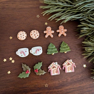 May include: A set of 10 Christmas-themed polymer clay earrings. The earrings feature gingerbread men, cookies, hot chocolate mugs, holly leaves, Christmas trees, and gingerbread houses.