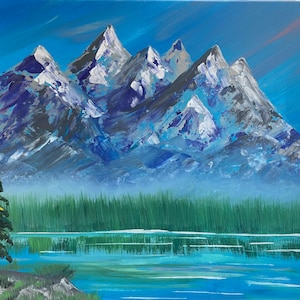 May include: An acrylic painting of a mountain range with snow-capped peaks. The mountains are painted in shades of gray, blue, and white, with a blue sky background. A green forest and a lake are in the foreground.