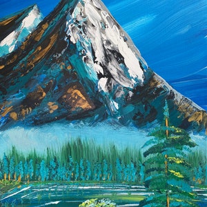 May include: Acrylic painting of a mountain landscape. The artwork features a snow-capped mountain with blue, white, and gold accents. A forest of green trees and a lake are in the foreground, under a blue sky.
