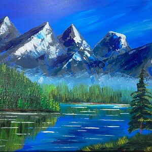 May include: An acrylic painting of a mountain landscape. The artwork depicts snow-capped mountains, a serene lake, and lush green trees. The sky is a gradient of blue, and the water reflects the surrounding scenery. A single evergreen tree stands on the lake's edge.