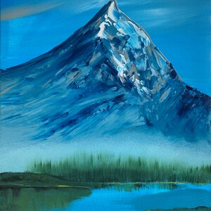 May include: An original acrylic painting of a snow-capped mountain peak. The artwork features a blue sky, a mountain with shades of blue and white, a green forest, and a blue lake in the foreground. The painting has a textured, brushstroke style.