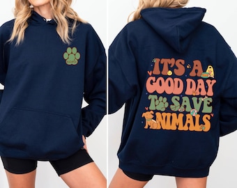 May include: Navy blue hoodie with a green paw print and the word "nicole" on the left side. The back of the hoodie has a graphic that says "It's a good day to save animals" with illustrations of a dog, bone, tennis ball, and other animal-related items.