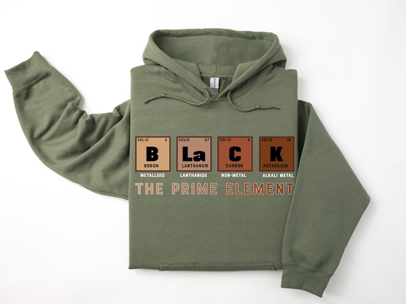 Puede incluir: Una sudadera con capucha verde con la palabra "BLACK" deletreada usando los s&iacute;mbolos qu&iacute;micos del boro, lantano, carbono y potasio. El texto "THE PRIME ELEMENT" est&aacute; impreso debajo de los s&iacute;mbolos qu&iacute;micos.