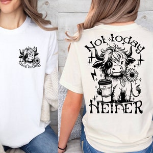 May include: White t-shirt with a black and white illustration of a cow with a sunflower and the text "Not today" on the front. The back of the shirt has a larger illustration of the cow with a coffee cup and the text "Not today Heifer".