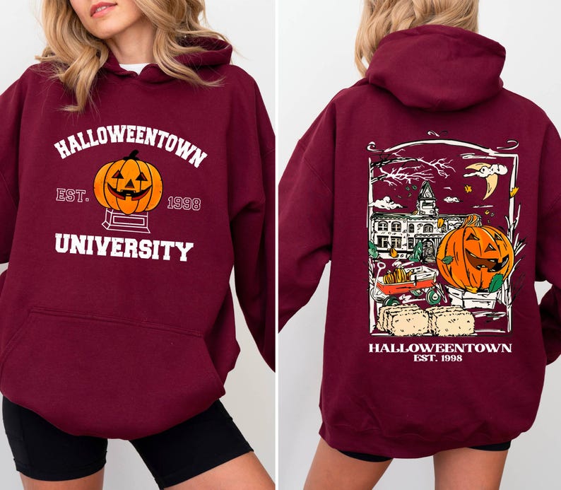 May include: Burgundy hooded sweatshirt with "Halloweentown University" text and a jack-o'-lantern graphic on the front. The back features a detailed Halloween-themed illustration with a pumpkin, buildings, and the text "Halloweentown Est. 1998".