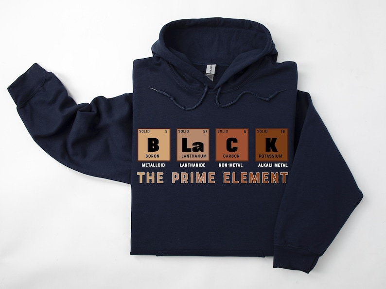 Puede incluir: Sudadera con capucha azul marino con un gr&aacute;fico de la palabra "BLACK" deletreada usando los s&iacute;mbolos qu&iacute;micos de boro, lantano, carbono y potasio. El texto "THE PRIME ELEMENT" est&aacute; impreso debajo del gr&aacute;fico.