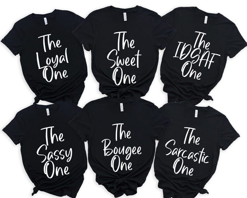 Peut inclure: Six t-shirts noirs avec du texte blanc. Les t-shirts affichent les inscriptions "The Loyal One", "The Sweet One", "The IDSAF One", "The Sassy One", "The Bougee One" et "The Sarcastic One".