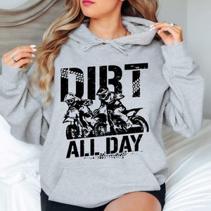May include: A gray hoodie with a black graphic print of two people riding dirt bikes. The text "DIRT ALL DAY" is printed below the image.