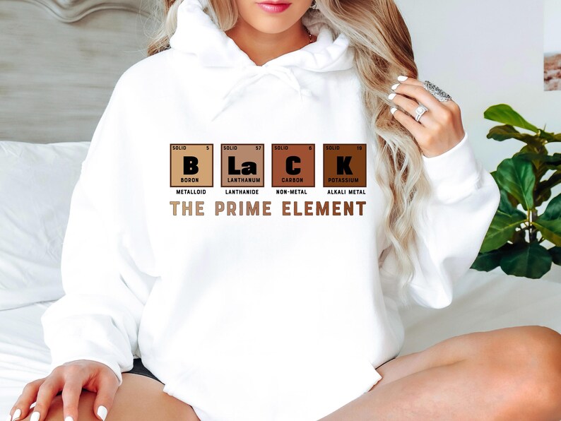 Puede incluir: Sudadera blanca con un gr&aacute;fico de la tabla peri&oacute;dica de los elementos que deletrea "BLACK" con las palabras "The Prime Element" debajo. Los elementos son B, La, C y K, que representan Boro, Lantano, Carbono y Potasio.