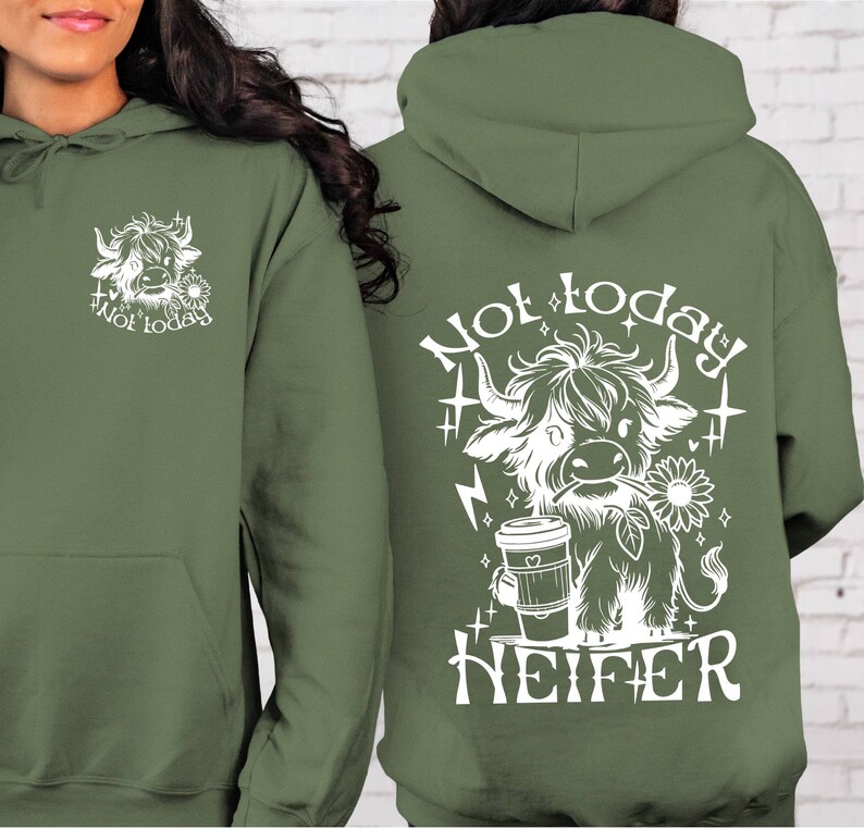 Może przedstawiać: Zielona bluza z kapturem z białym nadrukiem przedstawiającym krowę szkocką trzymającą kubek kawy i tekstem "Not today Heifer".