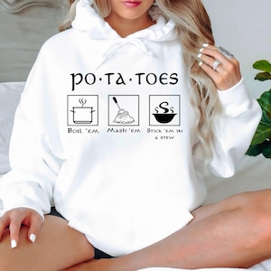 May include: White hoodie with a black graphic that says "po.ta.toes" and shows three ways to prepare potatoes: boil 'em, mash 'em, and stick 'em in a stew.