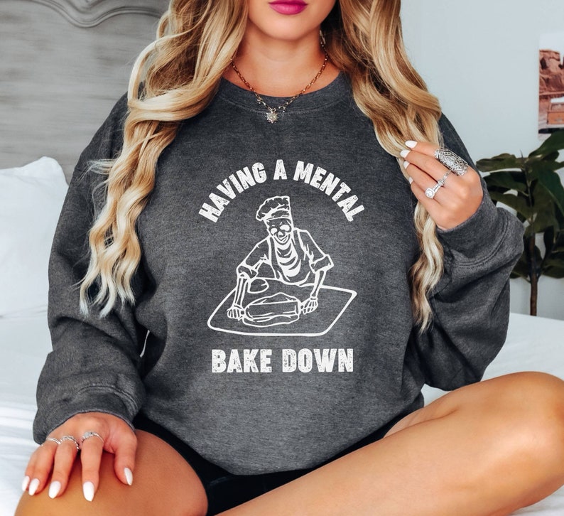 May include: A dark gray sweatshirt with the text "Having a mental bake down" and a skeleton baking.
