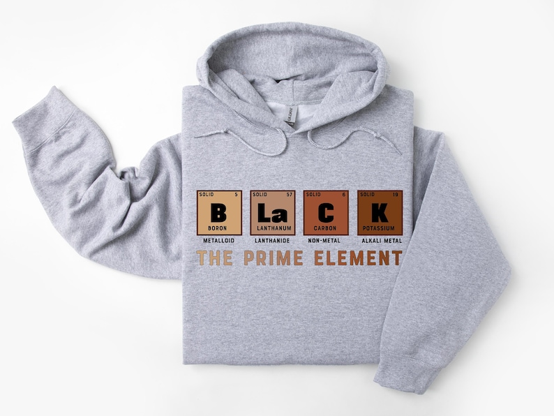 Puede incluir: Una sudadera con capucha gris con la palabra "BLACK" escrita usando los s&iacute;mbolos qu&iacute;micos del boro, lantano, carbono y potasio. El texto "THE PRIME ELEMENT" est&aacute; impreso debajo de los s&iacute;mbolos qu&iacute;micos.