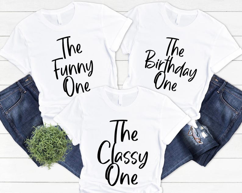 Peut inclure: Trois t-shirts blancs avec du texte noir. Les t-shirts disent "The Funny One", "The Birthday One", et "The Classy One".