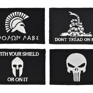 May include: Four black embroidered patches with white designs. The top left patch features a Spartan helmet with the text "MOLON LABE". The top right patch features a coiled snake with the text "DONT TREAD ON ME". The bottom left patch features a Spartan helmet with the text "WITH YOUR SHIELD OR ON IT". The bottom right patch features a skull with a crossbones.