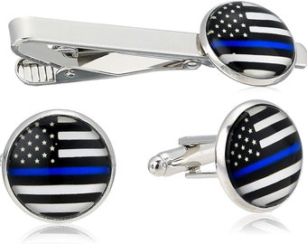 May include: A silver-toned tie clip and a pair of cufflinks. The cufflinks and the tie clip feature a design of the American flag with a blue stripe. The flag design is set in a round, silver-toned setting.
