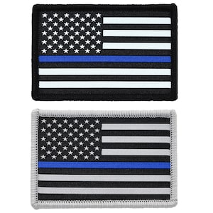 May include: Two embroidered American flag patches with a blue stripe across the middle. The top patch has a black background and the bottom patch has a gray background.