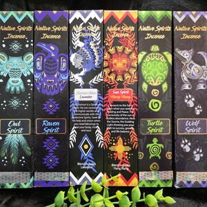 May include: Six boxes of Native Spirits incense are displayed, each with a unique design and color scheme. The boxes feature illustrations of an owl, raven, Native American figure, sun, turtle, and wolf. The text on the boxes includes the words "Owl Spirit," "Raven Spirit," "Lavender," "Sun Spirit Ylang Ylang," "Turtle Spirit," and "Wolf Spirit."