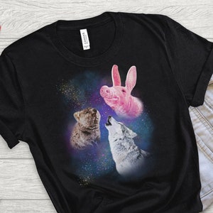 May include: Black t-shirt with a graphic of a pink pig, a brown wolf, and a gray wolf howling at the moon in a galaxy print.