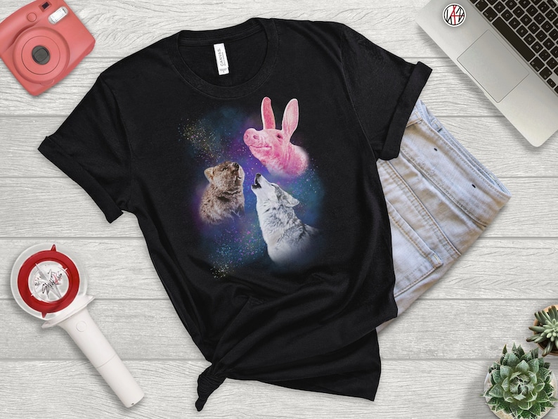 May include: Black t-shirt with a graphic of a pink pig, a brown wolf, and a gray wolf howling at the moon in a galaxy print.