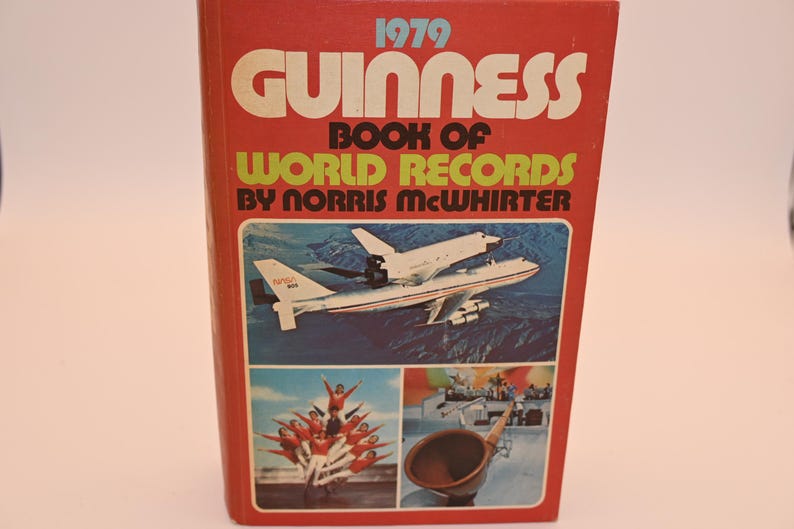 May include: A vintage 1979 Guinness Book of World Records. The cover is red with white and green text. The cover features images of an airplane, a group of people, and a horn.
