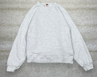 May include: A light gray sweatshirt with long sleeves and a crew neck. The Fruit of the Loom logo is visible on the neckline. The sweatshirt is made of a soft, comfortable material.