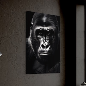 May include: A black and white close-up photograph of a gorilla's face. The gorilla is looking directly at the camera with a serious expression.