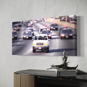 May include: A white SUV drives down a highway with other cars in the background. The SUV is in focus, while the other cars are blurred.