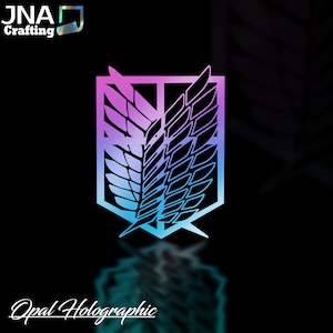 Puede incluir: Una calcoman&iacute;a hologr&aacute;fica con el emblema del Cuerpo de Exploraci&oacute;n de la serie de anime "Ataque a los Titanes". El dise&ntilde;o muestra un escudo con alas, en un degradado de p&uacute;rpura, azul y turquesa. El texto "Opal Holographic" est&aacute; en la parte inferior.
