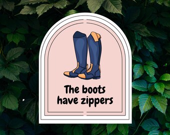 May include: A sticker featuring a pair of blue riding boots with tan accents. The text "The boots have zippers" is below the boots. The sticker is set against a background of green leaves.