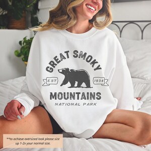 May include: White sweatshirt with a black and white graphic print of a bear and the text "Great Smoky Mountains National Park" with the text "Est 1934".